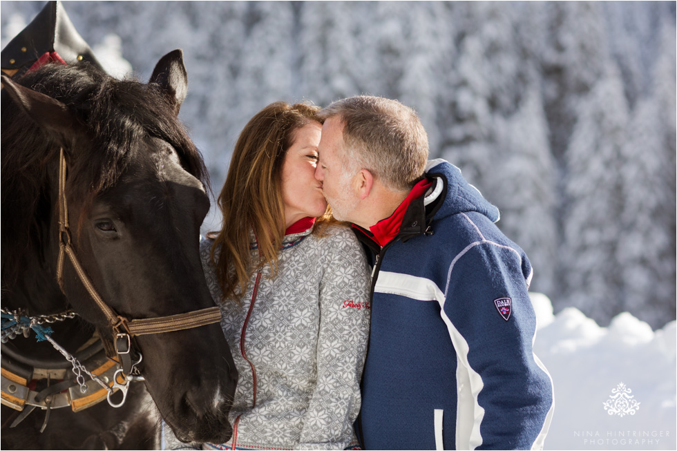 kissing couple with horses during a sleigh ride in st. anton am arlberg - Blog of Nina Hintringer Photography - Wedding Photography, Wedding Reportage and Destination Weddings