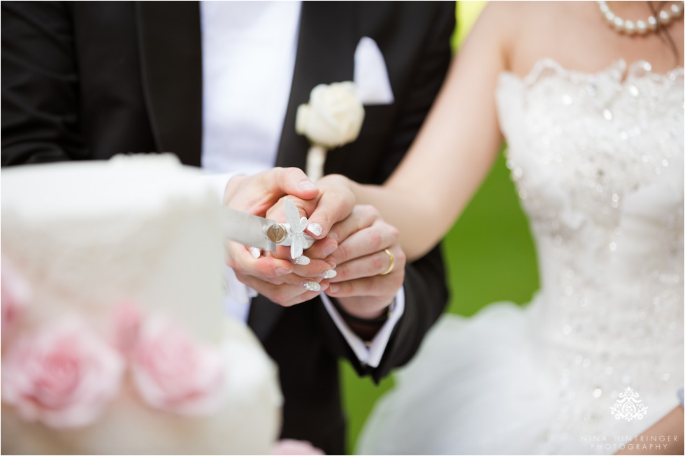 Bride and groom cutting the cake in the garden of Schloss Prielau, Zell am See, Salzburg, Austria - Blog of Nina Hintringer Photography - Wedding Photography, Wedding Reportage and Destination Weddings